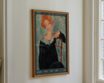 Pode incluir: Uma impressão artística emoldurada de uma mulher com cabelo ruivo, sentada em uma cadeira. A obra de arte apresenta uma mulher em um vestido preto com gola branca, apoiando o braço no encosto da cadeira. O texto na parte inferior diz "WOMAN WITH RED HAIR - 1917".