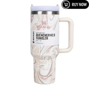 May include: A Stanley Quencher H2.0 Tumbler with a white lid and handle. The stainless steel tumbler features a marble-like pattern in shades of white and pink. The text "QUENCHER H2.0 TUMBLER" is printed on the front. It holds 40 oz.