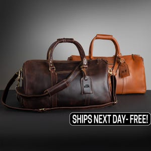 May include: Two leather duffel bags, one dark brown and one tan, with top handles and shoulder straps. Each bag has a luggage tag with initials. The dark brown bag has the initials "hIk" on its tag. The tan bag has the initials "DF" on its tag.