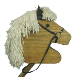 May include: Wooden toy horse head with a white yarn mane and a black leather bridle. The horse has a brown wooden body and black eyes.