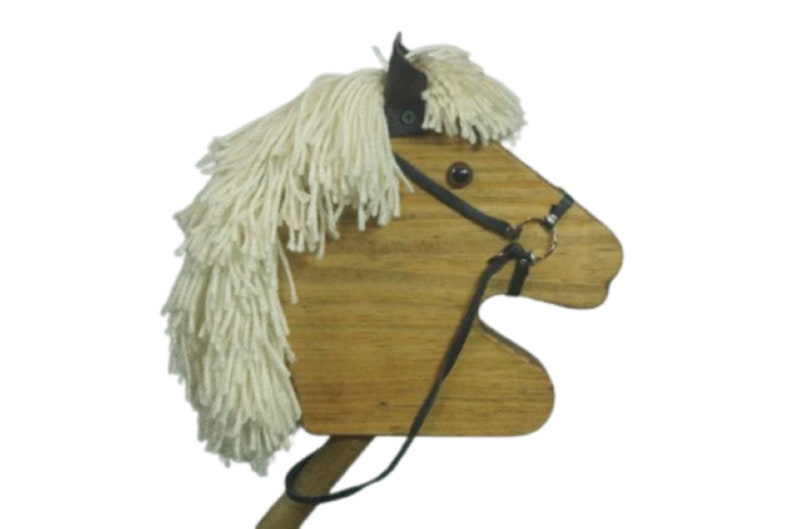 May include: Wooden toy horse head with a white yarn mane and a black leather bridle. The horse has a brown wooden body and black eyes.