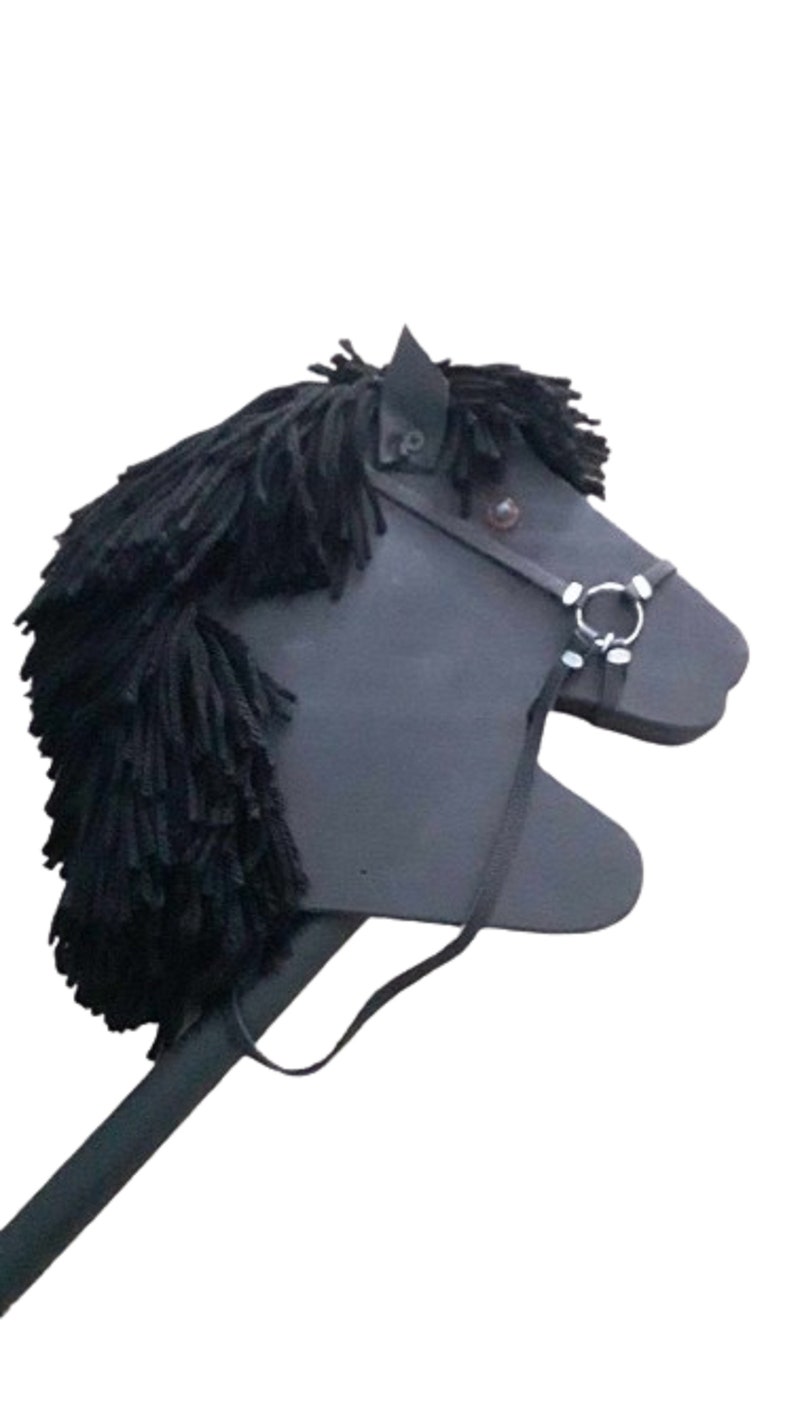 May include: A black wooden stick horse toy with a black mane and a leather bridle with a silver ring.
