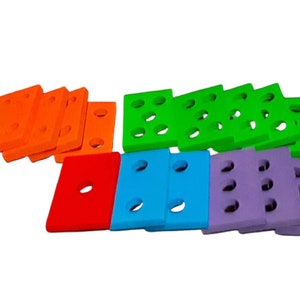 May include: A set of colorful foam building blocks with holes. The blocks are orange, green, red, blue, and purple.