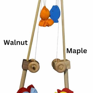 May include: A wooden fishing game with two poles, one walnut and one maple. The poles have a string with a hook and a red ball at the top. There are colorful felt fish to catch.