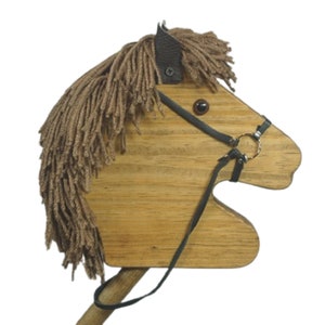 May include: Wooden toy horse head with brown yarn mane and black leather bridle. The horse has a brown wooden body and black eyes.