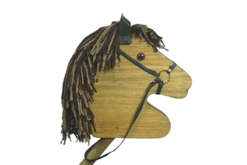 May include: Wooden toy horse head with brown yarn mane and black leather bridle. The horse has a brown eye and a black nose.