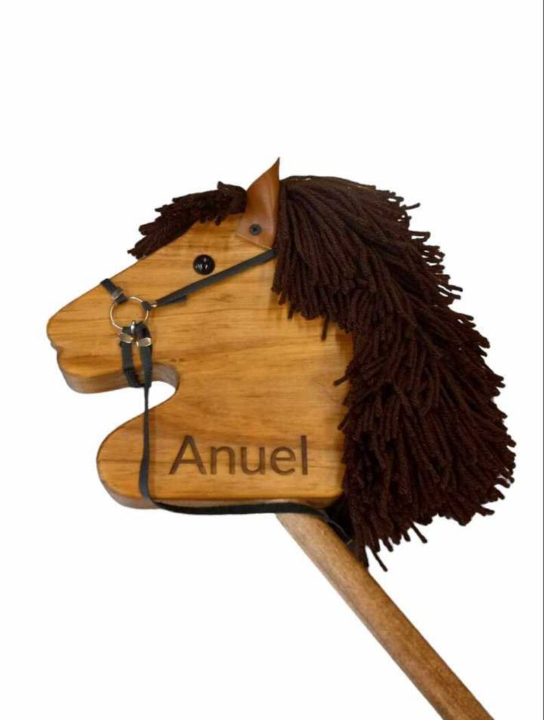 May include: A wooden toy horse with a brown mane and tail, a black bridle, and the name "Anuel" engraved on the side.