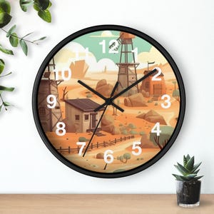 Könnte beinhalten: Eine runde Wanduhr mit schwarzem Rahmen. Das Zifferblatt zeigt eine Wüstenlandschaft mit Windmühle, Gebäuden und Felsen. Weiße Zahlen markieren die Stunden. Die Zeiger der Uhr sind schwarz.