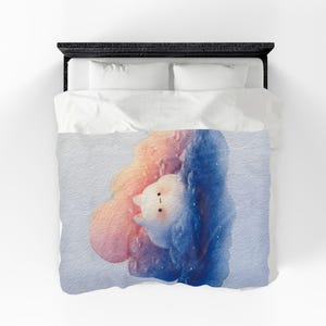 May include: A white duvet cover featuring a central watercolour illustration of a small, round, white creature with simple black eyes and a mouth, nestled within a cloud-like shape transitioning from soft orange and pink to deep blue.
