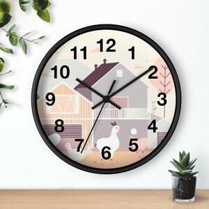 Könnte beinhalten: Eine Wanduhr mit schwarzem Rahmen und einer Illustration einer Bauernhofszene. Das Zifferblatt zeigt ein Haus, eine Scheune und Nutztiere. Die Zahlen sind in einer schwarzen, gut lesbaren Schrift. Die Zeiger der Uhr sind schwarz.