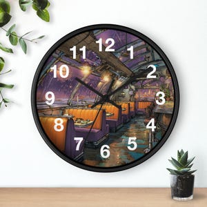 May include: A circular wall clock with a black surround. The clock face depicts a detailed illustration of a diner interior with orange booths, purple seating, and a starry night sky. The clock hands are black.