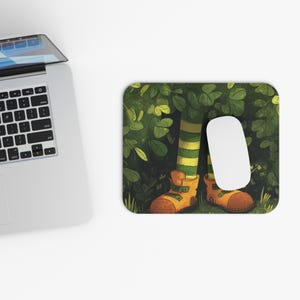 Pode incluir: Um mousepad caprichoso com uma ilustração de desenho animado de pernas em meias listradas verdes e amarelas e botas laranja, cercadas por folhagem verde. Um mouse de computador branco repousa no lado direito.