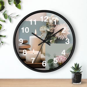 May include: A round wall clock with a black frame. The clock face features a collage of candles, flowers, and stones. White numbers mark the hours. The clock hands are black.