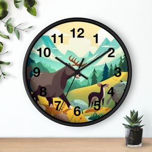 Könnte beinhalten: Eine runde Wanduhr mit schwarzem Rahmen und einem aufgedruckten Bild eines braunen Elchs und eines kleineren Hirsches in einer Berglandschaft mit Tannen, blauen Bergen und gelbem Himmel. Die Uhr hat schwarze Stunden-, Minuten- und Sekundenzeiger.