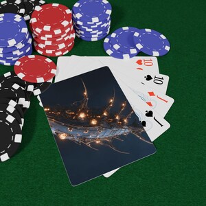 May include: A collection of red, blue, and black poker chips arranged in stacks alongside a hand of playing cards. The top card features a dark, abstract illustration of a glowing, spiky creature or structure with multiple warm orange lights.