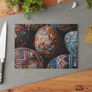 May include: A collection of intricately decorated, colorful Easter eggs. The eggs feature detailed patterns in shades of red, blue, yellow, and green. The image is a close-up, highlighting the texture and craftsmanship of the egg designs.