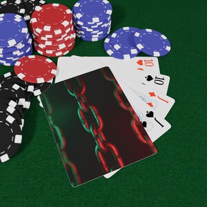 May include: Image of poker cards and chips on a green surface. The cards display the number 10 in various suits. Stacks of red, blue, black, and white poker chips are arranged around the cards. One card has a chain design.