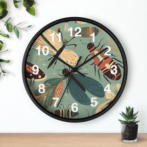 May include: A round wall clock with a black frame and a sage green face featuring a pattern of various insects and butterflies in shades of orange, blue, and brown. The clock has white numbers from 1 to 12 and thin black hour, minute, and second hands.
