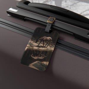 May include: A rectangular luggage tag with a black leather strap and gold buckle. The tag features a surrealist painting of a horse reflected in water, with a dark, moody color palette.