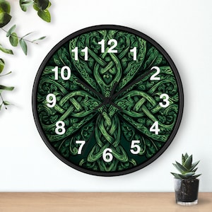 May include: Round wall clock with a black frame and a green Celtic knot design. The clock face features a detailed, symmetrical pattern with white numerals. The clock is approximately 12 inches in diameter.