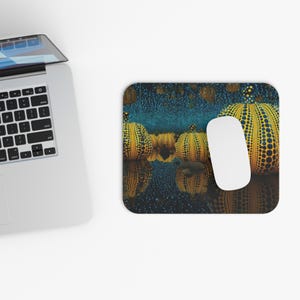 May include: A rectangular mouse mat featuring a surreal landscape of yellow pumpkins with black dots, set against a dark blue background. A white computer mouse rests on the mat, next to a laptop.
