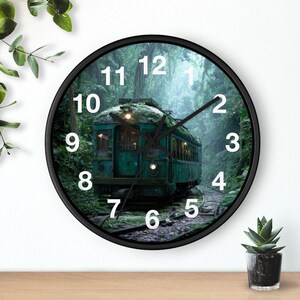 May include: A round wall clock with a black frame featuring a printed image of an old green train car sitting on tracks in a dense, misty forest. The clock face has large white numbers from one to twelve and black hour, minute, and second hands.