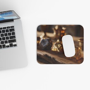 May include: A white computer mouse rests on a rectangular mousepad with a wooden texture. The mousepad features various golden objects, including a cube, a polyhedron, and a wrapped item, all set against a blurred background.