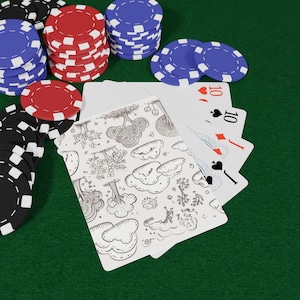 May include: A deck of playing cards with a black and white line art pattern of trees and clouds on the back, fanned out to reveal a ten of hearts, ten of spades, jack of diamonds, and jack of spades, surrounded by stacks of red, blue, and black chips.