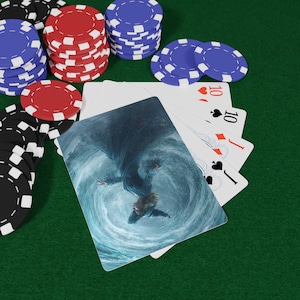 May include: Poker chips in black, red, and blue are stacked on a green felt surface. Playing cards with the number 10 and a graphic of a person in a whirlpool are fanned out. The scene suggests a game of poker.