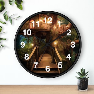Puede incluir: Un reloj de pared redondo con marco negro que presenta una imagen impresa de una casa del árbol de madera conectada por un puente. La esfera muestra números blancos grandes del 1 al 12 y tiene manecillas negras sobre la escena forestal.