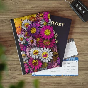 May include: A passport holder with a colorful floral design featuring smiling daisies in pink, purple, and white. A dark blue passport and two boarding passes are visible, along with a car key on a wooden surface.