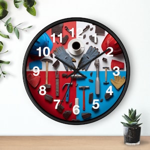 May include: A round wall clock with a black frame, featuring a red and blue segmented face. The clock face displays various construction tools and safety gear, including hammers, gloves, and hard hats. White numbers mark the hours.