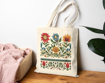May include: A cream-colored tote bag featuring a floral design with red, blue, and yellow flowers. The design includes green leaves and a blue border. The bag has two handles and is made of a canvas-like material.