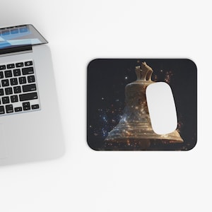 May include: A computer mouse and a mousepad featuring a detailed image of a bronze bell against a dark, starry background. The bell has intricate details and a weathered appearance, with a white mouse resting on the pad.
