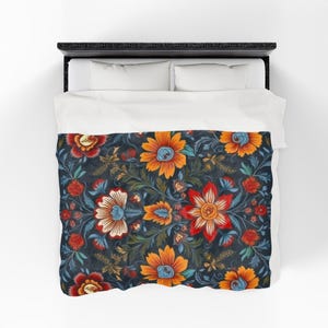 May include: A floral patterned duvet cover featuring large, stylized flowers in shades of orange, red, and blue against a dark navy background. The design includes intricate leaf and vine details, creating a rich, textured appearance. The bedding is placed on a bed with white pillows.
