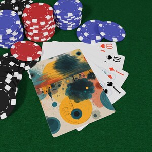 以下が含まれることがあります： 赤、黒、青のポーカーチップとトランプのセット。トランプには様々なスートの10が表示されています。1枚のカードには、黄色、青、オレンジ色を使った抽象的なデザインが施されています。