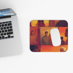 May include: A rectangular mouse mat with a collage of people in warm tones of orange, red, and brown. A white computer mouse rests on the right side of the mat, next to a laptop.