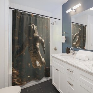 May include: A shower curtain featuring a high-resolution graphic print of an astronaut floating in deep space. The design displays a detailed white space suit against a dark, nebulous background with scattered light particles and cosmic debris.