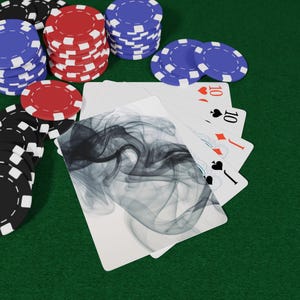 May include: Poker-themed image featuring stacks of red, black, and blue casino chips, along with playing cards. The cards show the number 10 and suit symbols. The cards have a smoky design. The background is a green felt surface.