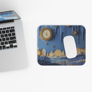 Pode incluir: Um mousepad azul e dourado com um design surrealista. O design apresenta relógios dourados, gotas azuis e uma paisagem. Um mouse branco está no lado direito do mousepad. O mousepad é retangular com cantos arredondados.