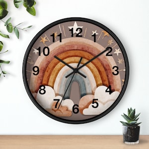 May include: A circular wall clock with a black surround. The clock face displays a rainbow design in brown, orange, and blue, with white clouds at the bottom. Gold stars and numbers are around the clock face.