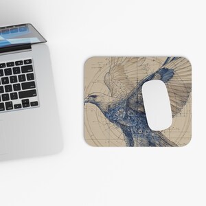 May include: A beige mouse mat with a detailed blue and white illustration of an eagle in flight. The design has a blueprint style with mechanical details. A white mouse sits on the mat.