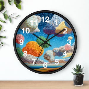 May include: Round wall clock with a black frame. The clock face features a colorful, dotted cloudscape design in shades of blue, orange, yellow, and pink. White numerals mark the hours, and black hands indicate the time.