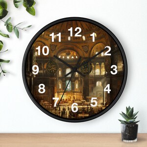 May include: A round wall clock with a black frame and white numbers. The clock face features a detailed, warm-toned interior view of the Hagia Sophia, including its large dome, arched architecture, and golden Arabic calligraphy medallions.