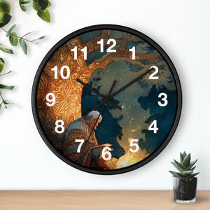May include: A circular wall clock with a black frame. The clock face displays an illustration of a person, a tree, and a celestial background. The numbers are white, and the hands are black.