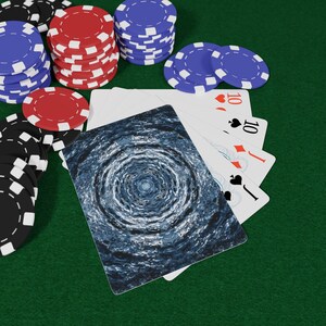 May include: Poker set with stacks of red, blue, and black poker chips on a green felt surface. Playing cards with the number 10 are visible, along with a card featuring a blue and white swirling design.