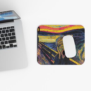 May include: A rectangular mousepad featuring Edvard Munch's "The Scream" painting. The mousepad has a black border and a white computer mouse is on top of the mousepad. The artwork depicts a figure with an open mouth against a colorful background.