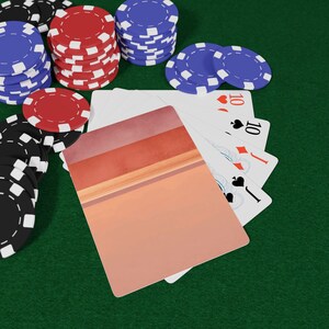 May include: A still life image of poker chips and playing cards on a green surface. Stacks of red, blue, and black poker chips surround a hand of playing cards. The cards show the number 10 and various suits.
