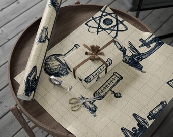 May include: A roll of science-themed wrapping paper and a wrapped gift box with a brown ribbon sit on a wooden table. The paper features dark blue sketches of lab equipment and scientific symbols on a grid background. A pair of scissors and a magnifying glass are also on the table.