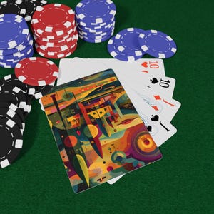 以下が含まれることがあります： 黒、赤、青のポーカーチップが緑色の表面に積み重ねられ、トランプが添えられています。カードには数字の10と様々なスートが表示されています。1枚のカードには抽象的でカラフルなデザインが施されています。